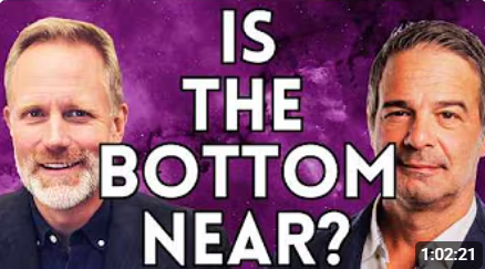 Two smiling men flank bold white text reading "Is the bottom near?" on a purple background